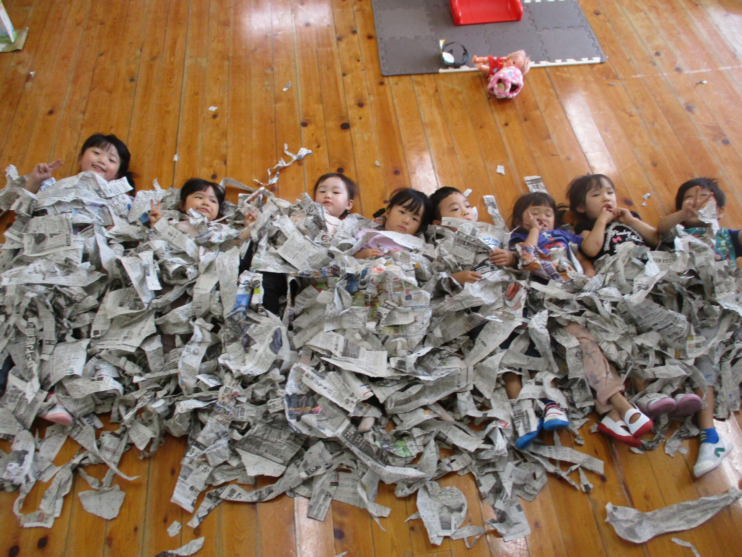 清水こども園のこどもたちの日常の様子の写真です。新聞で遊んでいます。