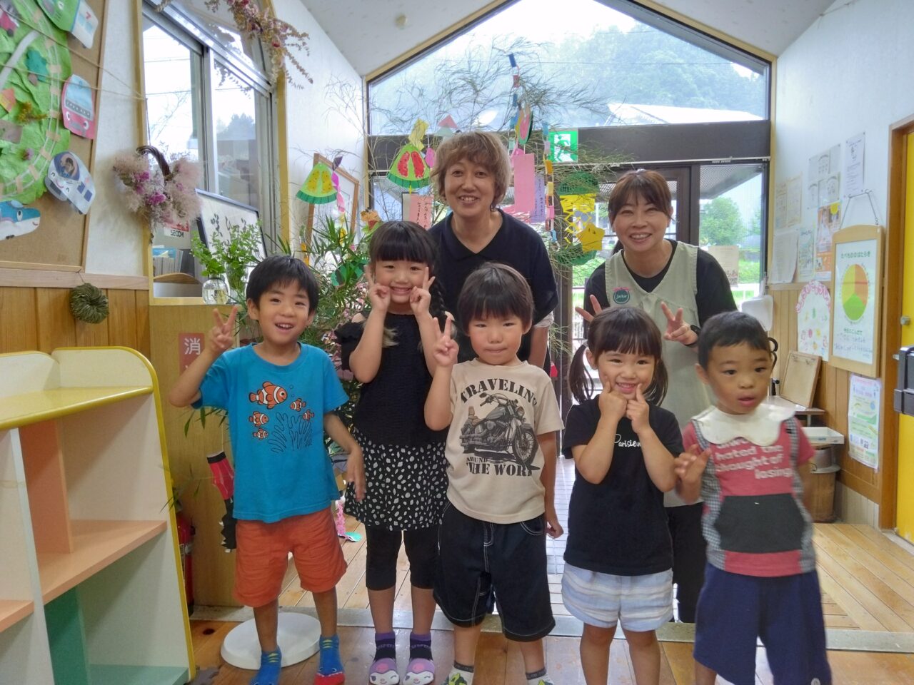 有田川町立清水こども園
新田 千寿　園長と長田 美代子 主幹保育教諭とこどもたちの写真です。